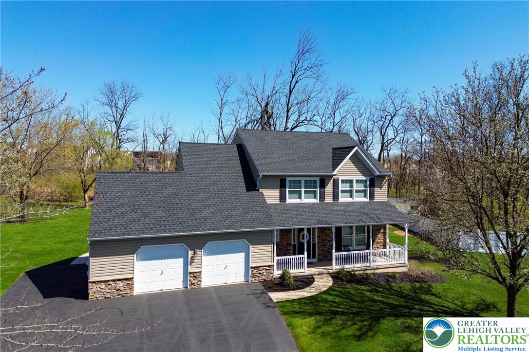 2053 Alice Drive Bethlehem, PA 18015 - Photo 1 of 31 a front view of a house with a garden and trees