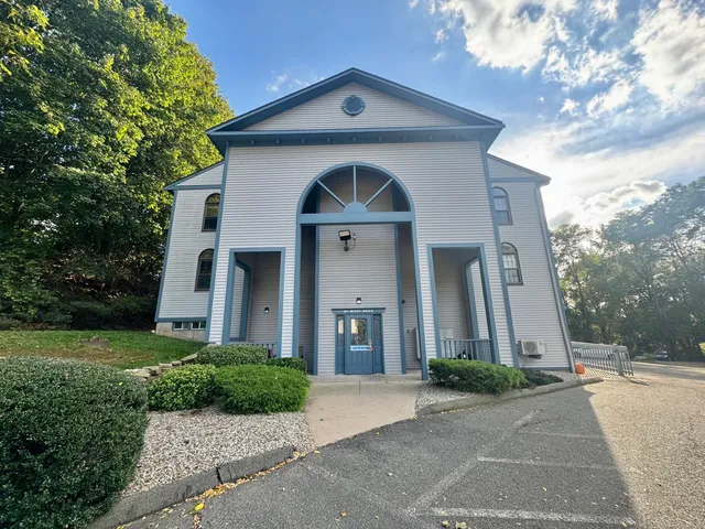 a front view of a house with yard and green space