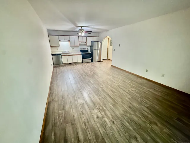 a view of a kitchen with cabinets and wooden floor