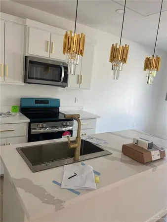 a kitchen with a sink a microwave and cabinets