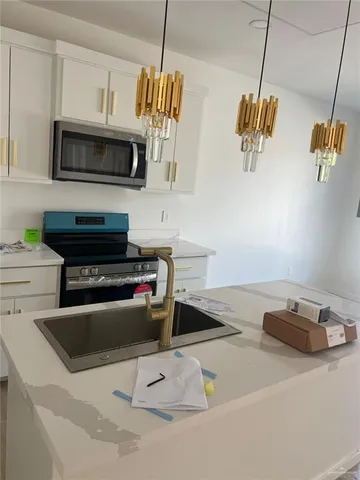 a kitchen with a sink a microwave and cabinets