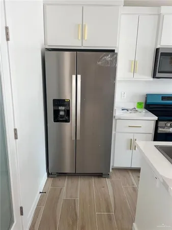 a kitchen with a refrigerator and a stove top oven