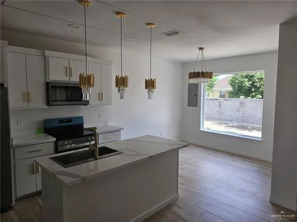 a kitchen with kitchen island a counter space a sink and appliances