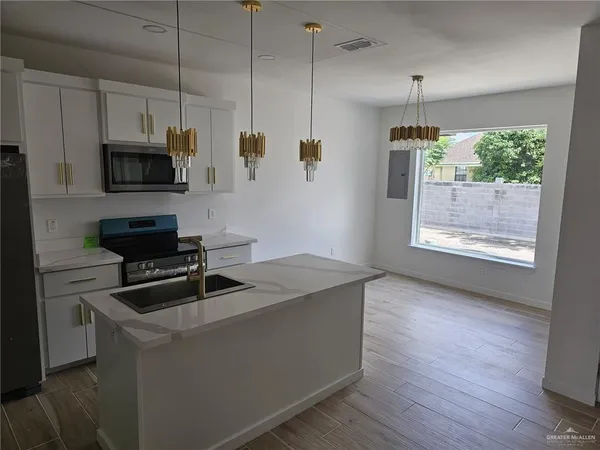 a kitchen that has a microwave a sink and a stove