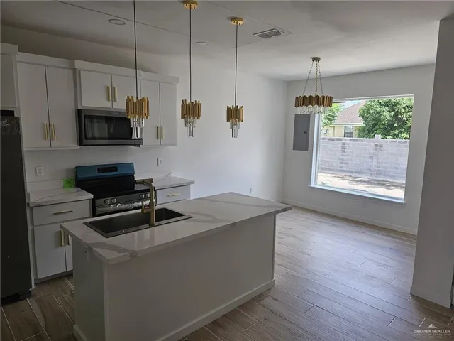 a kitchen that has a microwave a sink and a stove