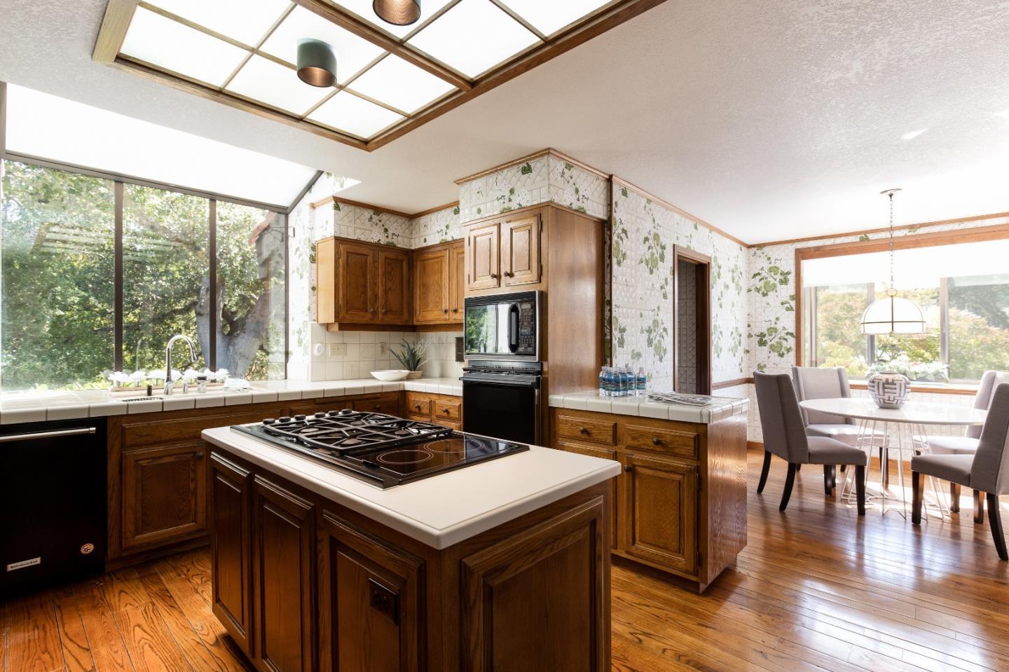 110 Stonepine Road Hillsborough, CA 94010 - Photo 10 of 28 a kitchen with a stove a sink dishwasher kitchen island with a dining table and chairs