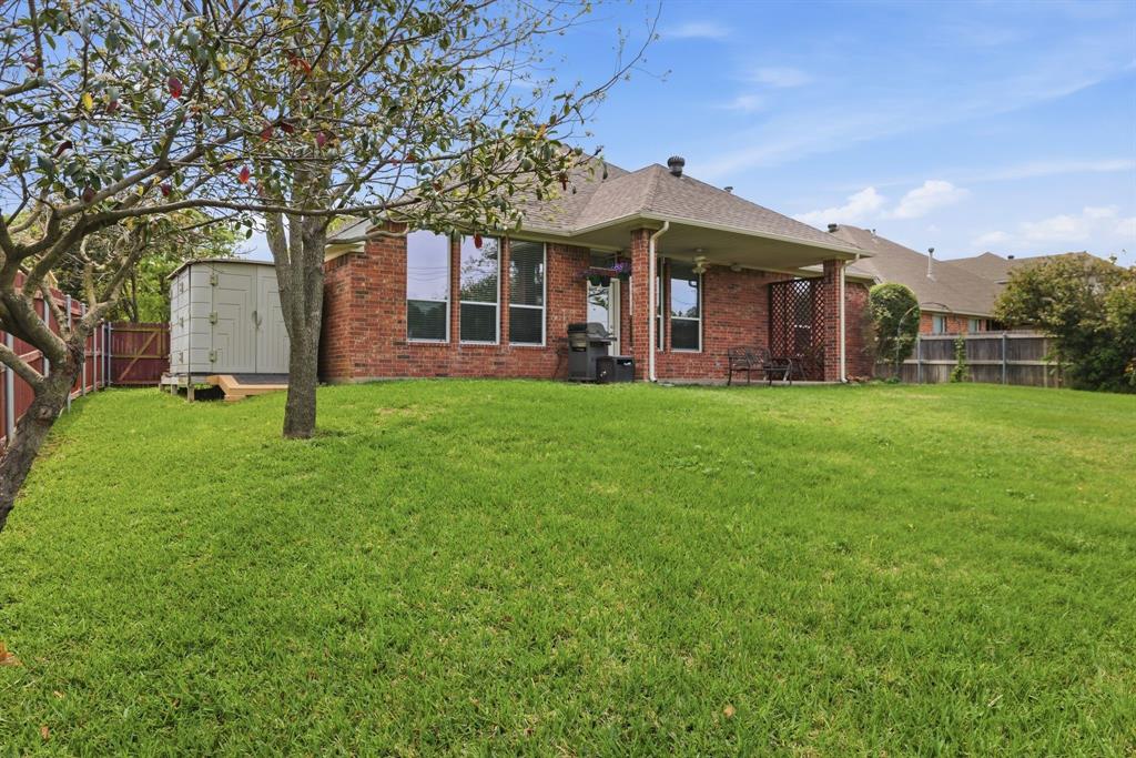 817 Huebner Way Burleson, TX 76028 - Photo 33 of 35 This shows the backyard, the storage building and back of the home which is all bricked.