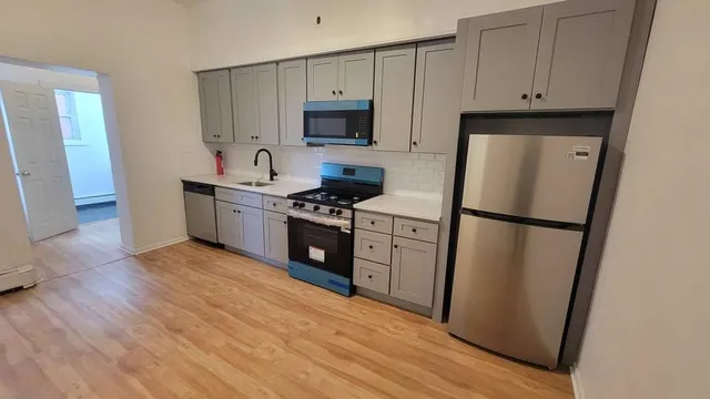 a kitchen with granite countertop a refrigerator stove and microwave