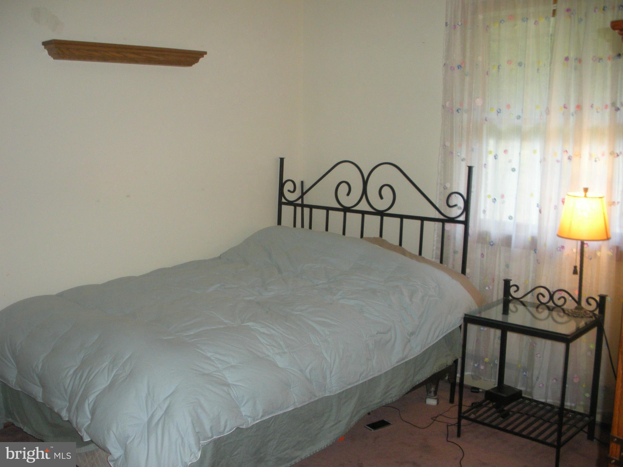 12309 Gramlich Road Southwest La Vale, MD 21502 - Photo 13 of 30 a bed sitting in a bedroom next to a lamp