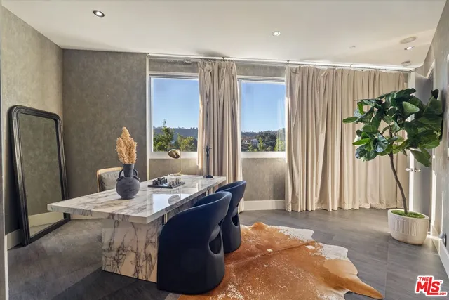 a dining room with furniture and a potted plant