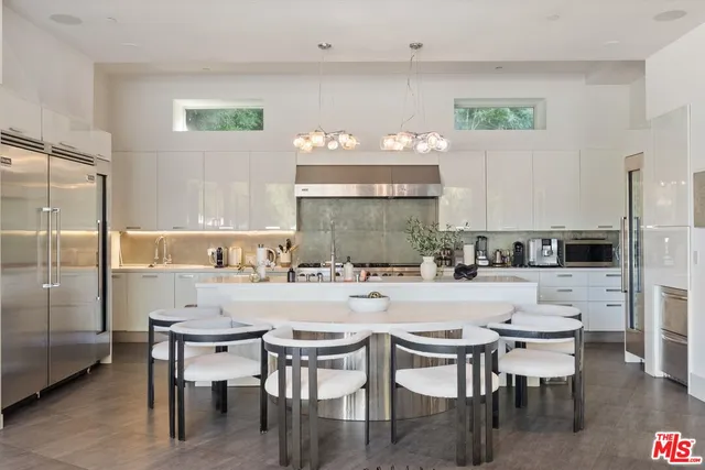 a kitchen with a table chairs stove and refrigerator