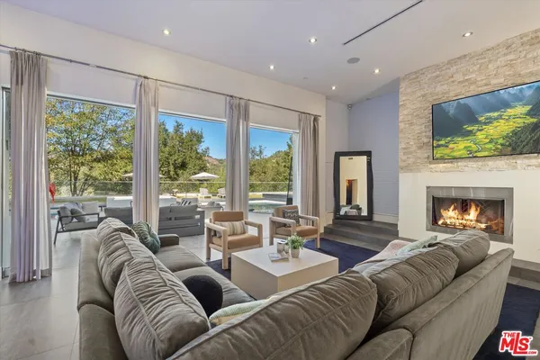 a living room with furniture fireplace and a large window