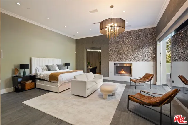 a spacious bedroom with a bed and a chandelier