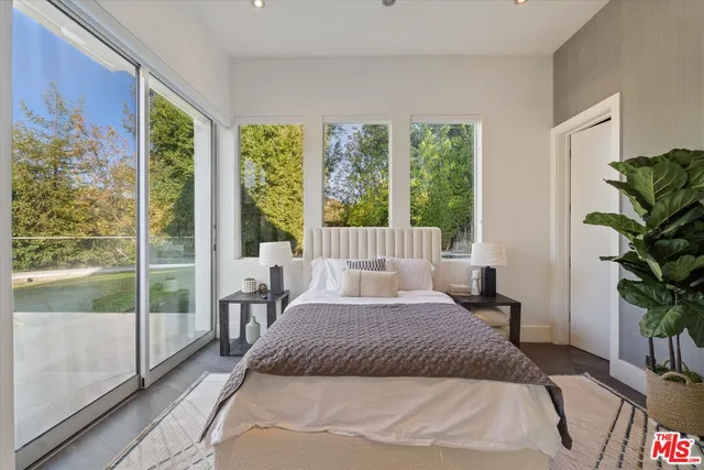 a bedroom with a large bed and a large window with outer view