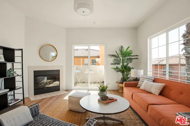 a living room with furniture a fireplace and a large window