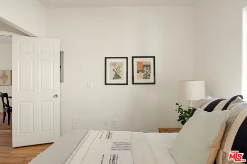 a view of a bedroom with wooden floor and closet