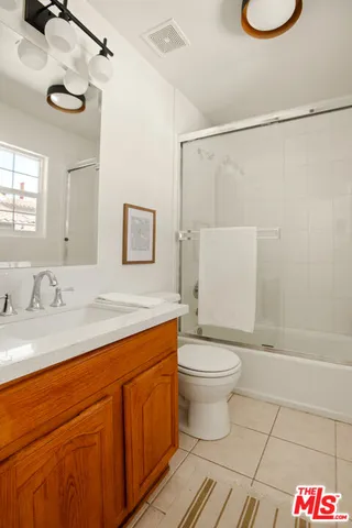 a bathroom with a granite countertop sink toilet a mirror and shower