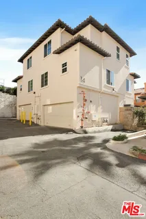 a view of a white house with a street