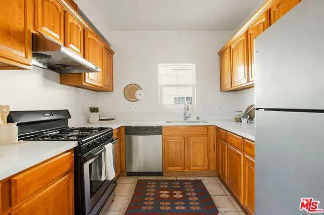 a kitchen with stainless steel appliances a stove a sink and a microwave