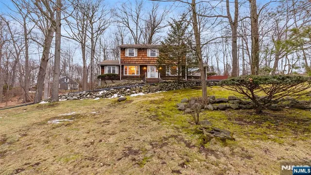 a view of a yard with a house and trees in the background