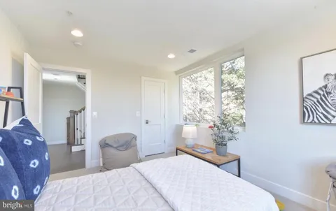 a bedroom with a bed a table and a large window