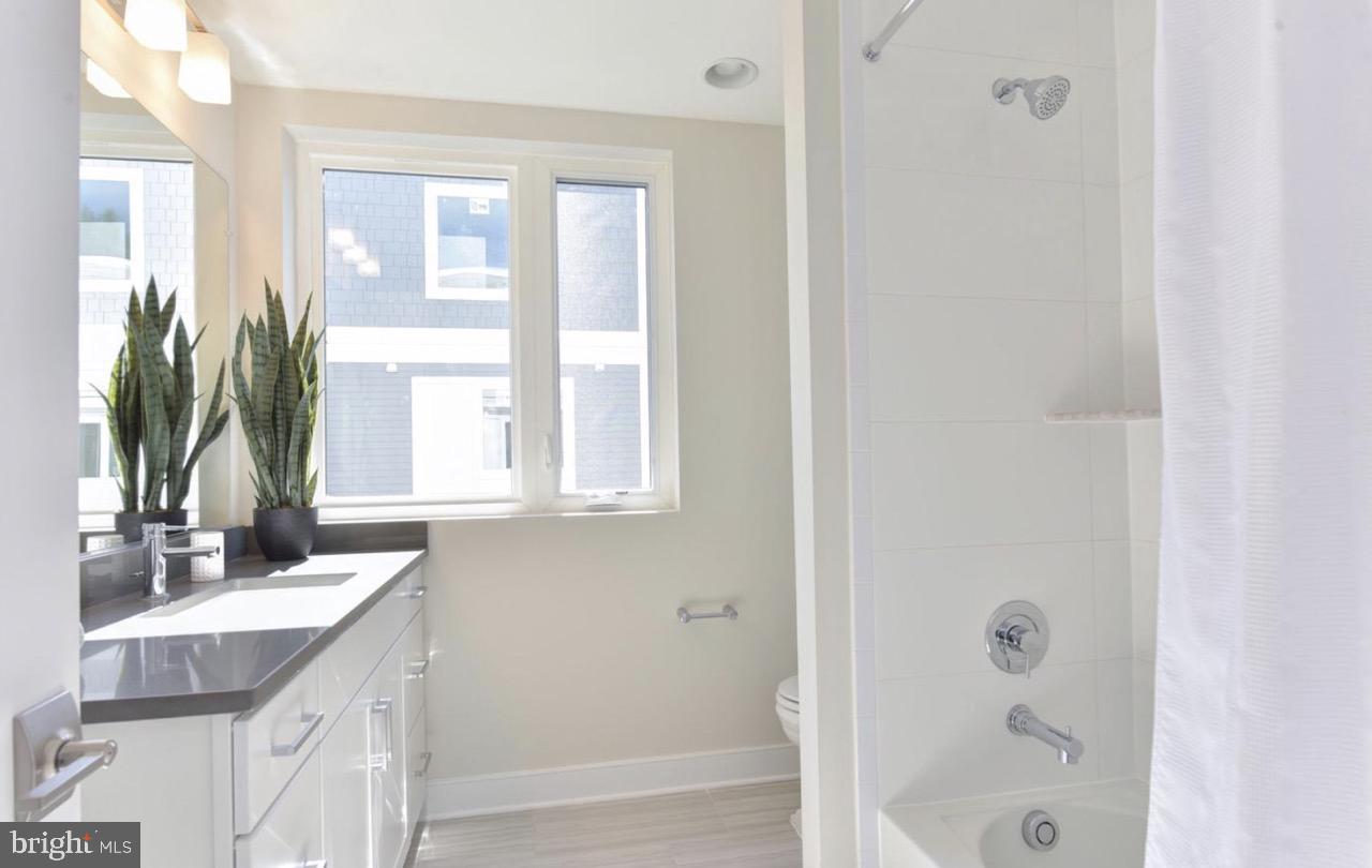 2815 24th Road South Arlington, VA 22206 - Photo 22 of 27 a bathroom with a granite countertop sink a mirror and a bathtub