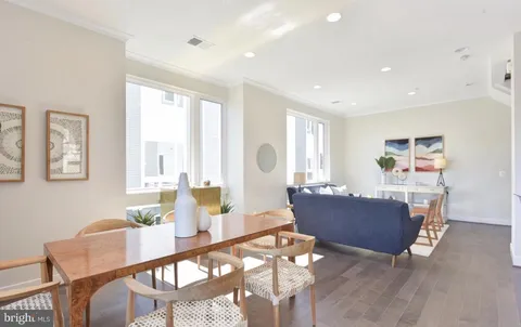a view of a dining room with furniture a chandelier and wooden floor