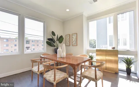 a living room with dining table and a large window