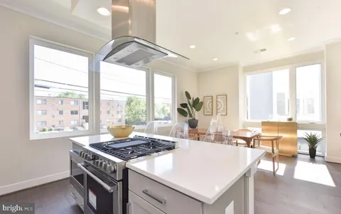a dining hall with stainless steel appliances granite countertop a stove and a large window