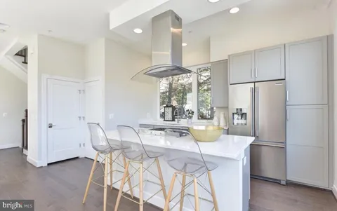 a kitchen with stainless steel appliances a sink cabinets and a large window
