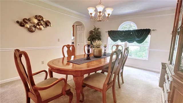 a view of a dining room with furniture a chandelier and wooden floor