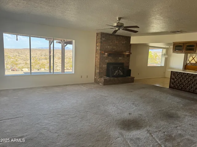 an empty room with a fireplace and windows