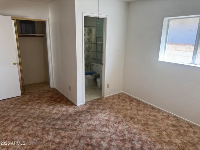 an empty room with windows and closet
