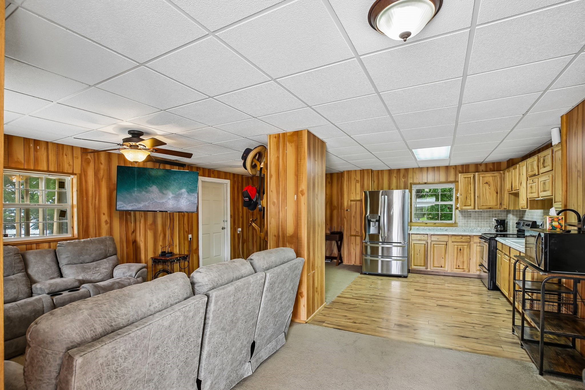 164 Frank Road Trinity, TX 75862 - Photo 14 of 20 This open-concept living and kitchen area serves as the heart of the home, radiating rustic charm with high-quality wood paneling throughout. The seamless flow between the functional kitchen and the cozy living space makes it an ideal layout for comfortable daily living and effortless entertaining.