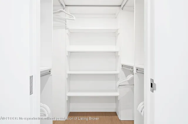 a view of walk in closet with empty racks