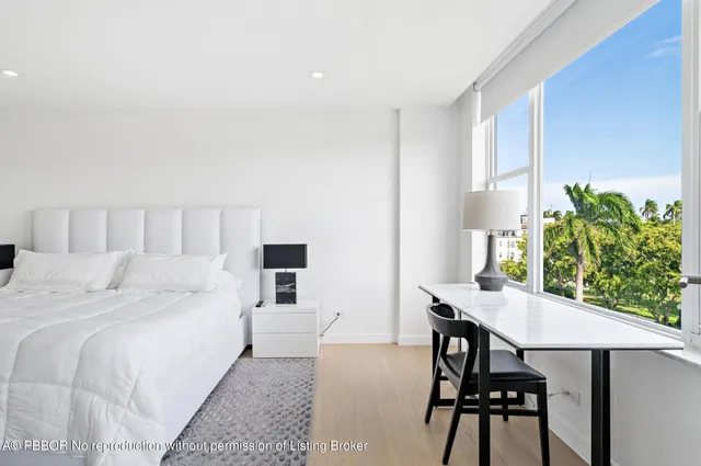 a bed room with a bed table and a chair