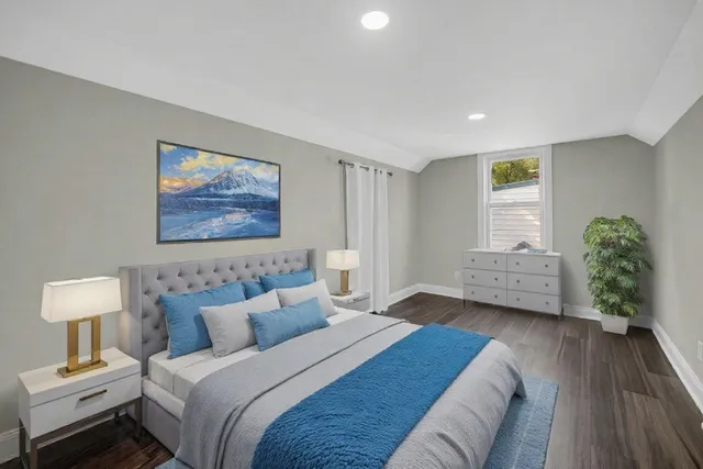 a spacious bedroom with a bed a couch and a window