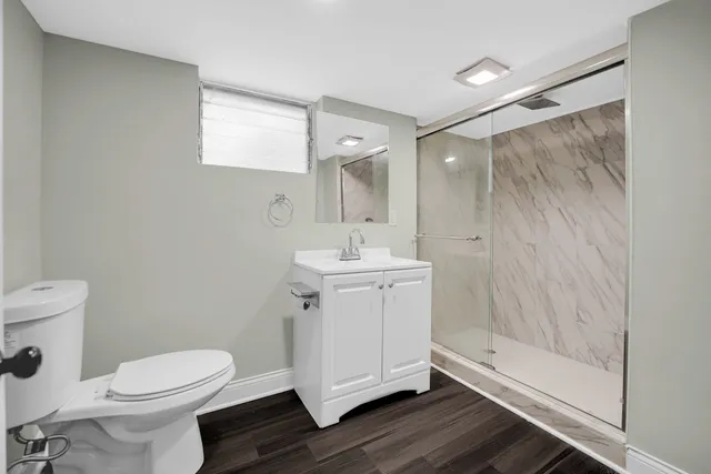 a bathroom with a sink a toilet and shower