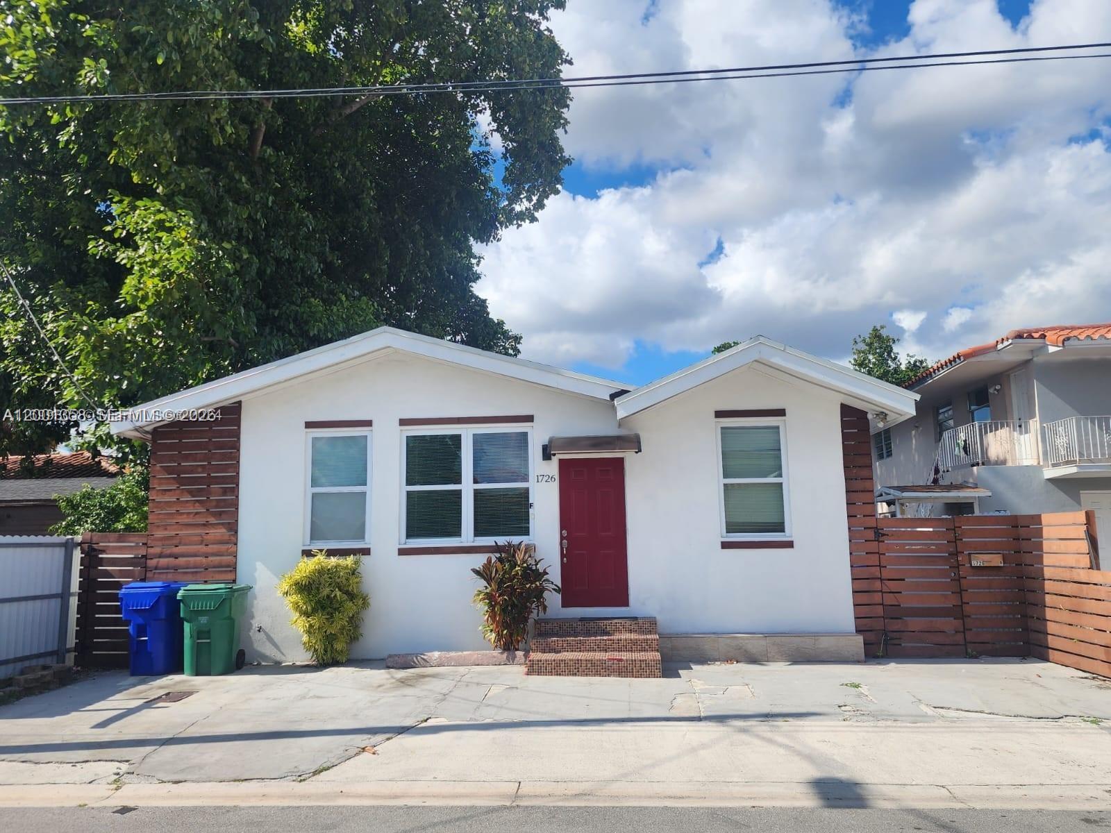 1726 Southwest 25th Avenue, Unit 1 Miami, FL 33145 - Photo 1 of 14 a front view of a house with a yard and garage