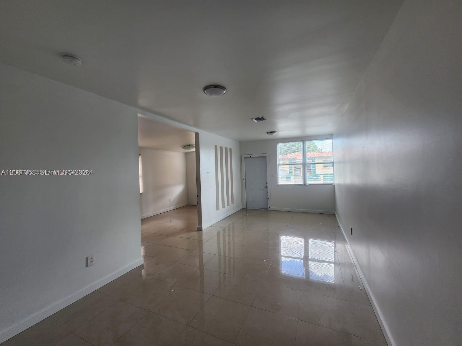 1726 Southwest 25th Avenue, Unit 1 Miami, FL 33145 - Photo 3 of 14 an empty room with windows and entrance