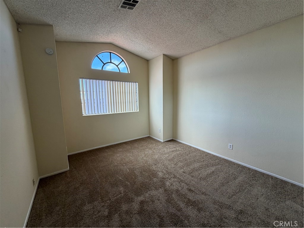 2560 East Ave R12 Palmdale, CA 93550 - Photo 17 of 26 an empty room with a fireplace and windows
