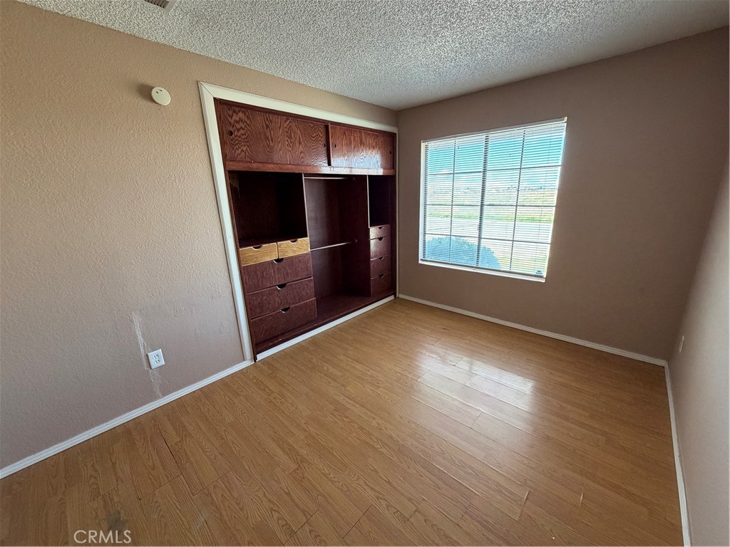2560 East Ave R12 Palmdale, CA 93550 - Photo 5 of 26 an empty room with wooden floor and window