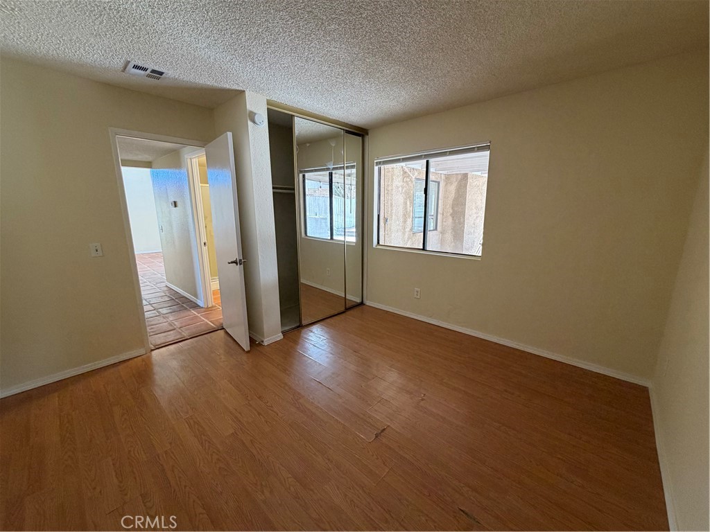 2560 East Ave R12 Palmdale, CA 93550 - Photo 7 of 26 an empty room with wooden floor and windows