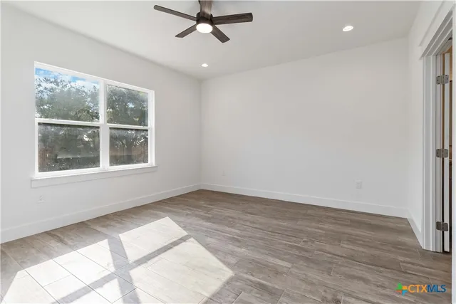 a view of an empty room with wooden floor