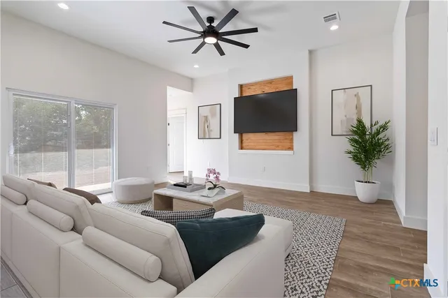 a living room with furniture a flat screen tv and a potted plant