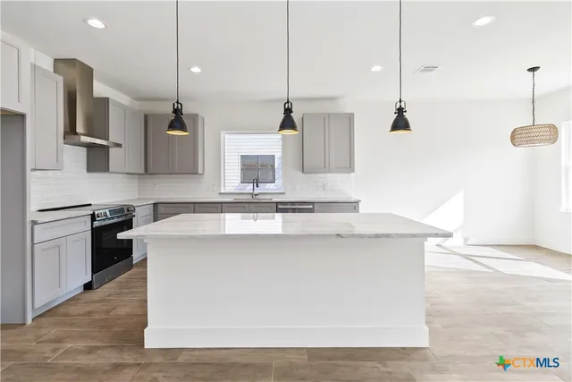 a kitchen with stainless steel appliances white cabinets and wooden floor