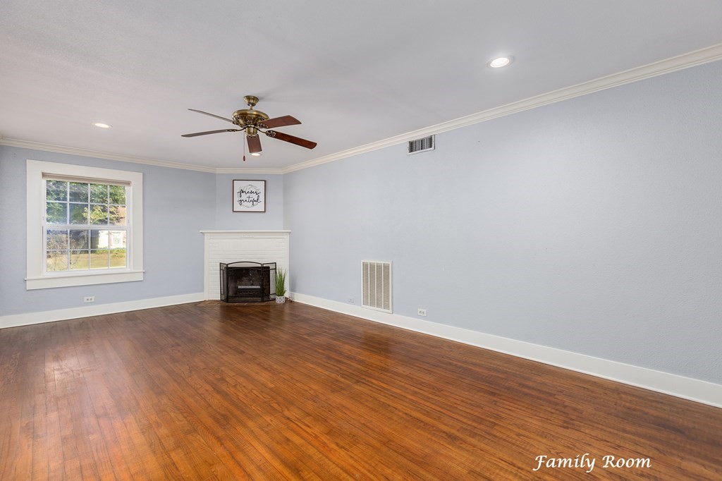 421 House Street Lufkin, TX 75904 - Photo 13 of 46 an empty room with wooden floor fireplace and windows