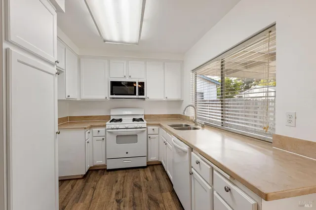a kitchen with a sink stove top oven and cabinets