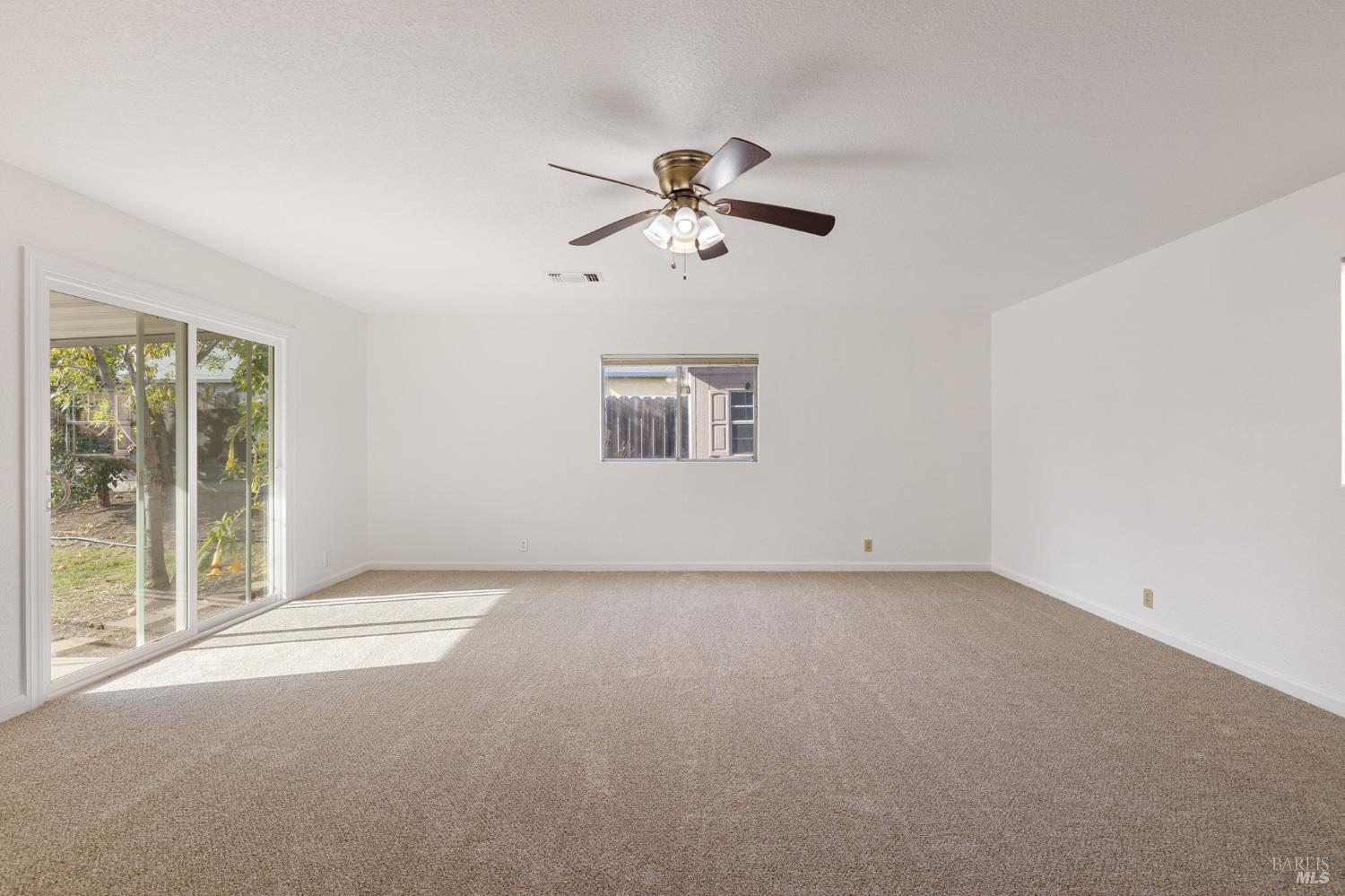570 Berkeley Way Fairfield, CA 94533 - Photo 20 of 34 a view of a big room with windows and chandelier fan