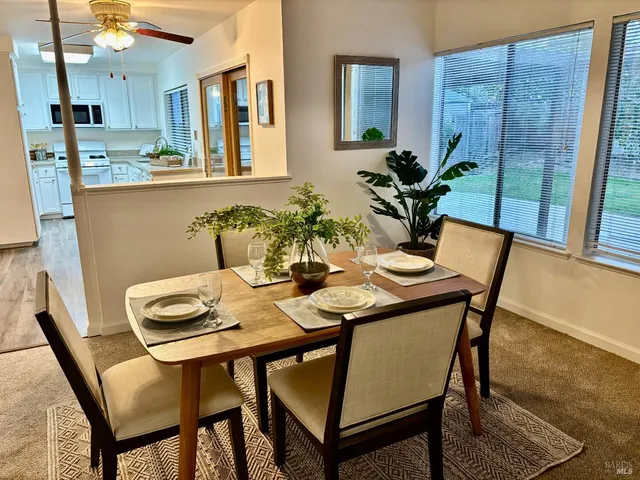 a view of a dining room with furniture and a potted plant